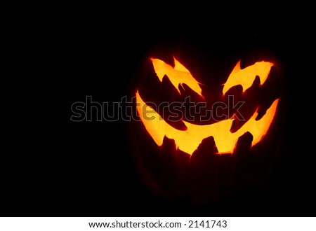 A close up of a pumpkin carved with for halloween.