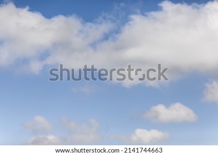 Cumulus and cirrus white clouds on a blue sky background