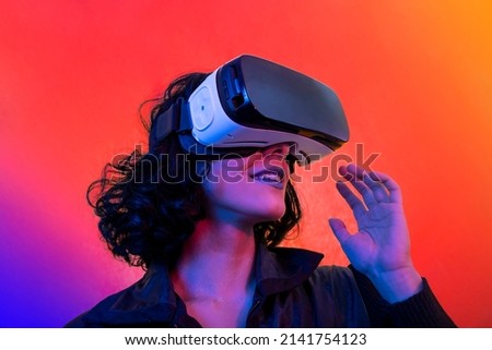 The young woman is using virtual reality viewer. Modern woman portrait with trendy look and bright colors. Royalty-Free Stock Photo #2141754123