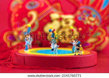 happy new year for kids playing in miniature creative festive scene.The Chinese characters in the picture mean: "Happiness"