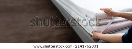 Mattress Topper Being Laid On Top Of The Bed Royalty-Free Stock Photo #2141762831