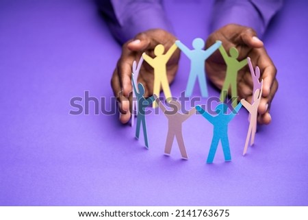 Inclusion, Diversity And Equality. African Hands Safeguard Paper Shapes Royalty-Free Stock Photo #2141763675