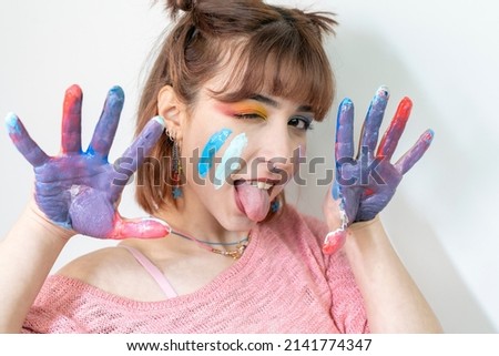 Happy woman showing hands painted in colorful paints on white background. Fun concept  