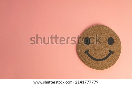 Smile Face icon on wooden circle cut over pink pastel background with copyspace for put text or logo.