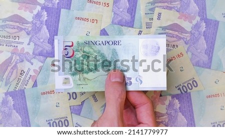 Businessman's hand holding Singapore Dollar Banknotes. Business Investment Economy Saving Loan Income Money and Finance concept. Prosperity concept. Five SGD . 5 SGD. Money Background.