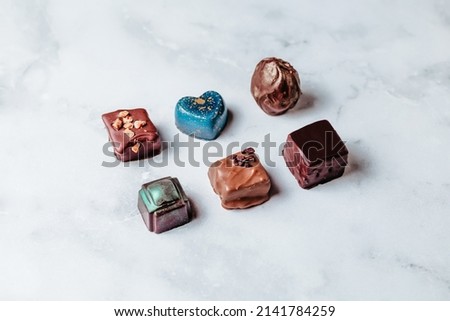 A set of handmade chocolates. Creative sweets made of natural chocolate with the addition of nuts. Minimalistic creative design of desserts