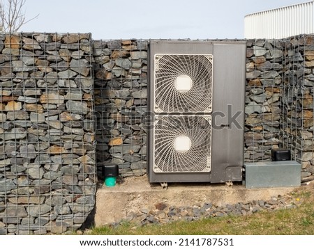 Air conditioning unit against a stone wall Royalty-Free Stock Photo #2141787531