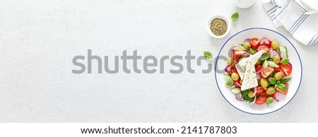 Banner salad. Greek or horiatiki salad with fresh vegetables and feta cheese, dressed with olive oil, traditional Greek cuisine salad. Top view. Banner