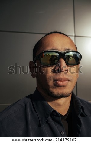 Portrait angry man screaming in studio. Closeup african american guy shouting on black background. Male model aggressive face expression. Serious man take off sunglasses. Displeased customer client