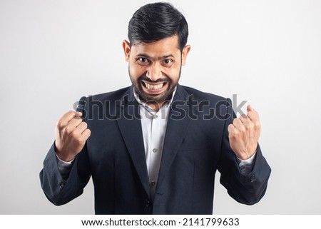 happy excited indian businessman celebrating success in grey background