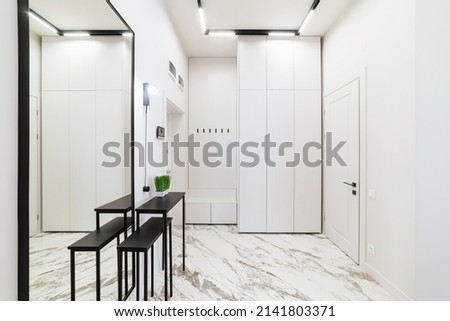new bright interior of the apartment with a white closet and a mirror