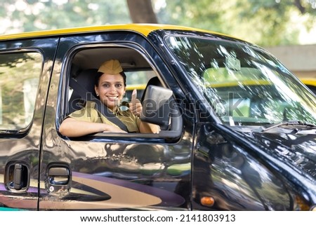Woman taxi driver giving thumbs up gesture

