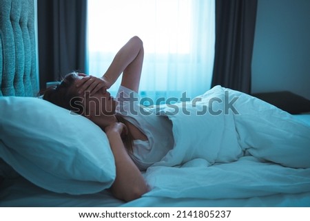 Woman with insomnia lying in bed with open eyes. Girl in bed suffering insomnia and sleep disorder thinking about his problem at night Royalty-Free Stock Photo #2141805237