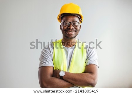 Happy African Builder Workman Standing Pleased Crossing Hands Posing On Gray Studio Background. Copy Space.  Industrial engineer  Royalty-Free Stock Photo #2141805419