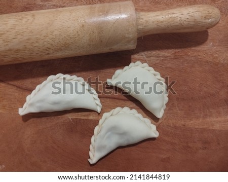 A picture of raw curry puff pastry which are preparing for frying. Popular Malaysian food.