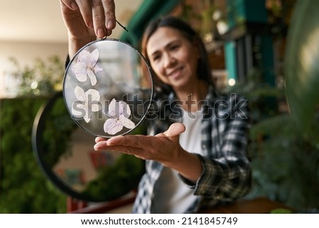 Designer holding elegant round glass with flowers