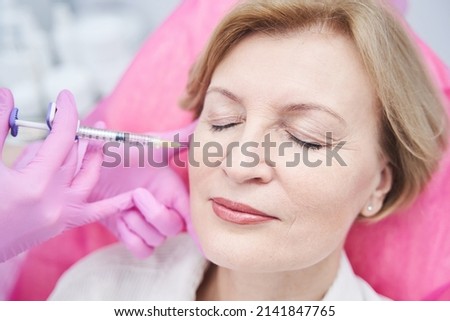 Focused photo on mature patient keeping eyes closed