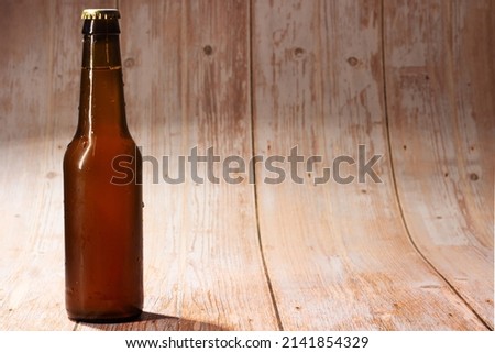 closed beer bottle on light wood background