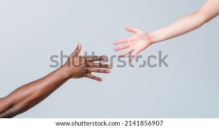 Giving a helping hand to another. Woman and african woman hand. Helping hand, Rescue, multiathnic people. Helping hands, Rescue gesture. Black and white human hands. African and caucasian hands. Royalty-Free Stock Photo #2141856907