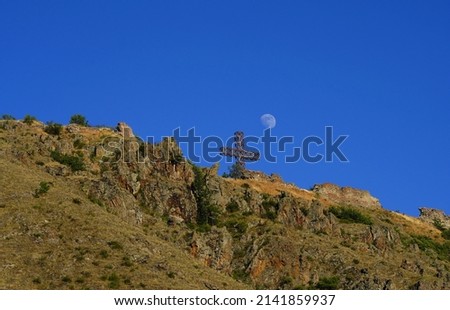 The half moon and mountain. Cross, symbol of christianity.