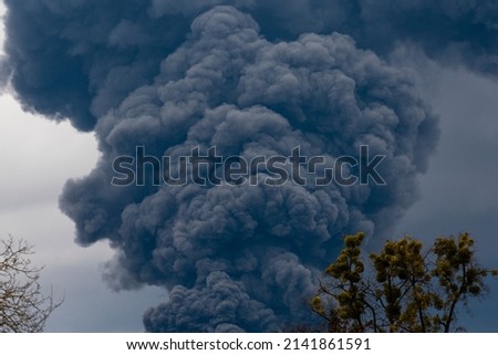 Thick black smoke covers the sky during the war between Ukraine and Russia. Disaster in Ukraine. Aggression war russia against Ukraine Royalty-Free Stock Photo #2141861591