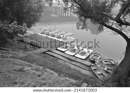 Black and white photo of a boat station, foggy spring morning over the river
