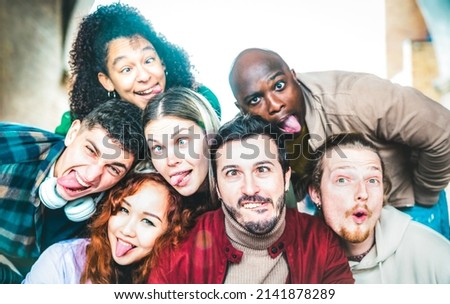 Multicultural guys and girls taking funny selfie out side - Happy life style concept by young multiethnic friends having fun together - Bright vivid backlight filter - Focus on mid mustache guy
