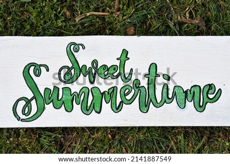 Sweet summertime sign with a grass background