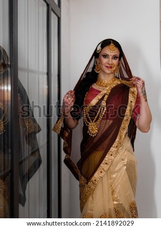 Portrait of beautiful indian girl. Young India woman model with jewelry set and mehendi. Traditional Indian costume lehenga choli or sari.