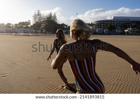 women having fun on the beach running