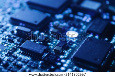 Computer Microchips on Electronic circuit board. Technology microelectronics concept background. Macro shot, selective focus, extremely shallow DOF. Noises and large grain - stylization under film. Royalty-Free Stock Photo #2141902667