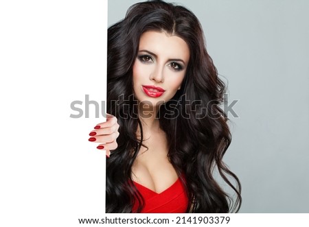 Amazing lady holding big white placard on grey background. Cute woman with empty paper board
