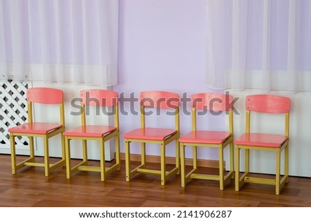 Pink wooden children's chairs in the room.