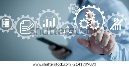 Operations management involving business process and workflow, problem solving, high performance, monitoring and evaluation, quality control. Concept with manager touching gears and icons. Royalty-Free Stock Photo #2141909093