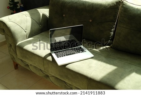 laptop on the green sofa in the room nobody

