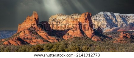 Red Rock pinnacles with dark sky with sun rays south of Sedona, Arizona.