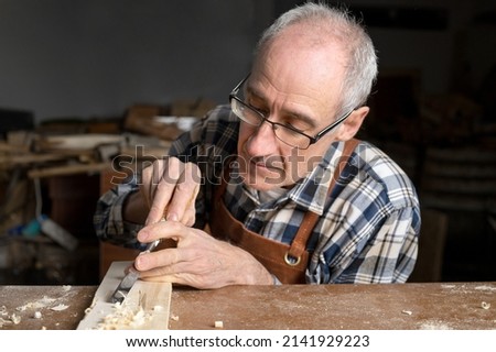 Close up of a Carpenter carving wood with chisel . High quality photography.