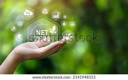 The concept of carbon neutral and net zero. natural environment A climate-neutral long-term strategy greenhouse gas emissions targets with green net center icon on hand cap and green background Royalty-Free Stock Photo #2141948313