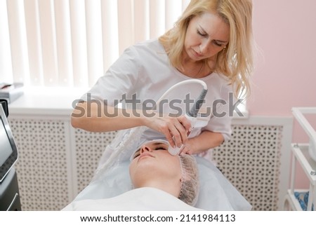 Lymphatic drainage massage apparatus massage process. Therapist cosmetologist makes a rejuvenating facial massage for a woman in a spa salon. Beauty and body concept. Royalty-Free Stock Photo #2141984113