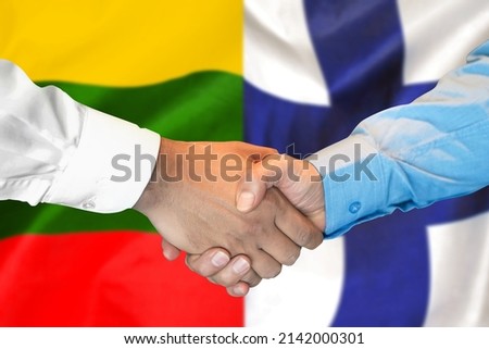 Business handshake on the background of two flags. Men handshake on the background of the Lithuania and Finland flag. Support concept