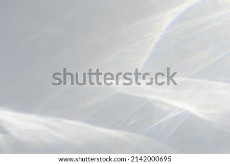 Blurred water texture overlay effect for photo and mockups. Organic drop diagonal shadow caustic effect with rainbow refraction of light on a white wall. Shadows for natural light effects Royalty-Free Stock Photo #2142000695