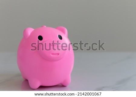 cute small bright pink piggy bank picture placed on the white table Suitable as a gift to children in every festival.to get to know  save money  white background There is an empty space on the right. 