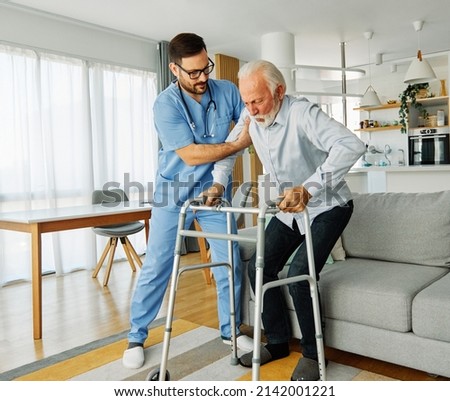 Doctor or nurse caregiver with senior man using walker assistanece  at home or nursing home Royalty-Free Stock Photo #2142001221