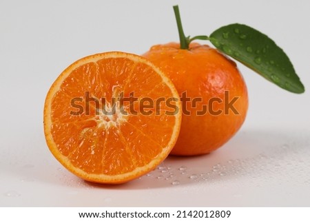 oranges, halved oranges, healthy fruit, mandarin oranges, vitamin C, against white background with refreshing water droplets