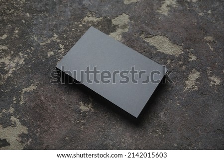 Stack of blank gray business cards on concrete background. Mock-up for branding identity.