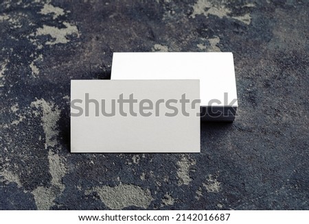 Photo of blank business cards on concrete background. For design presentations and portfolios. Mock-up for branding identity.