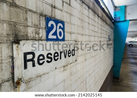 Signage for a reserved space  in a largely empty run down and dirty parking garage
