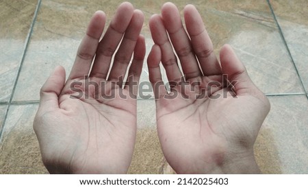 Raising both hands while praying to the creator.