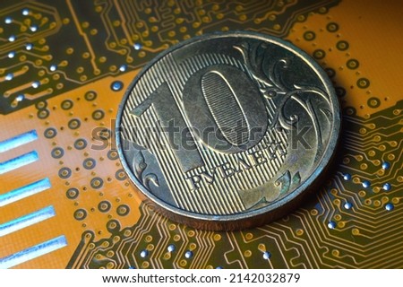A coin with a face value of 10 rubles lies on a microcircuit. close-up. Translation of the inscription on the coin: "10 rubles" The concept of the digital economy in the Russian Federation