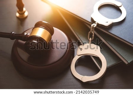 Handcuffs and wooden gavel. Crime and violence concept. Royalty-Free Stock Photo #2142035749